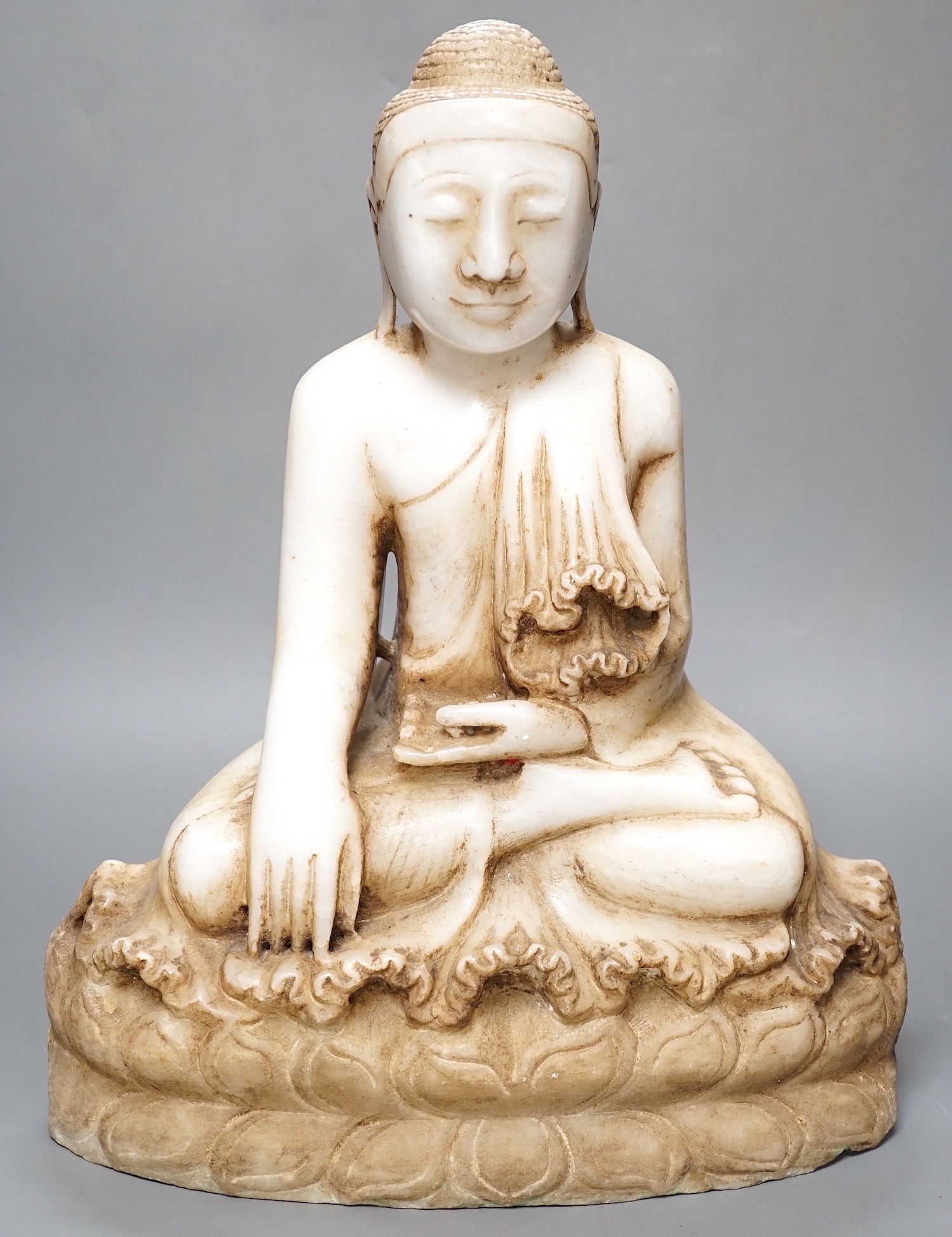 A Burmese carved marble seated Buddha on lotus throne, 20th century - 39cm high